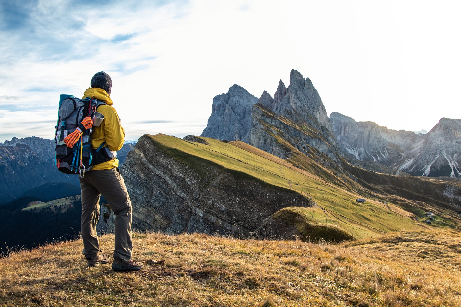 Hiker with a pack looking out over a mountain vista